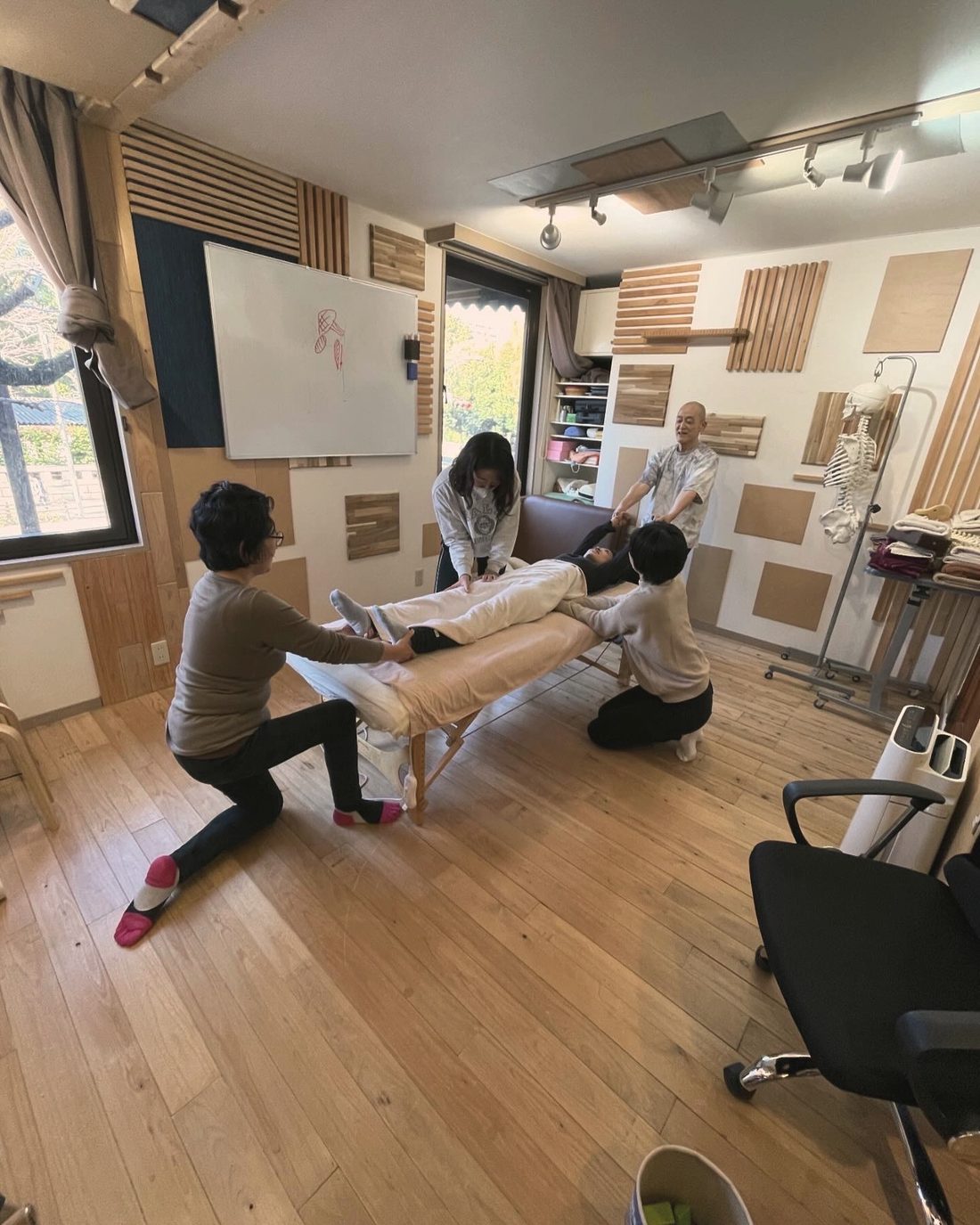 複数のセラピストが一人の身体に向き合う実技の様子